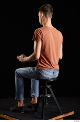 Alessandro Katz  black shoes blue jeans brown t shirt casual dressed sitting whole body  jpg